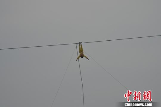 挑战者倒挂在钢丝上。 杨勇 摄 挑战者倒挂在钢丝上。 杨勇 摄